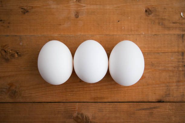 istock Three white eggs on the wooden background 1221606640