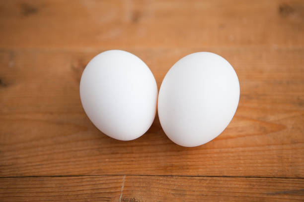 istock Two white eggs on the wooden background 1221606696