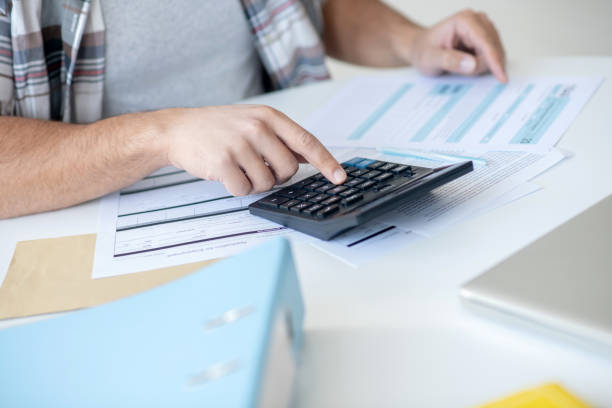 istock Close-up of male hands pressing buttons on calculator 1221606906