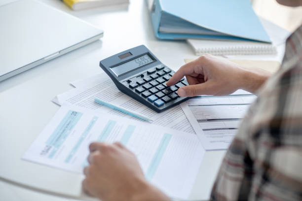 istock Close-up of male hands pressing buttons on calculator 1221606908
