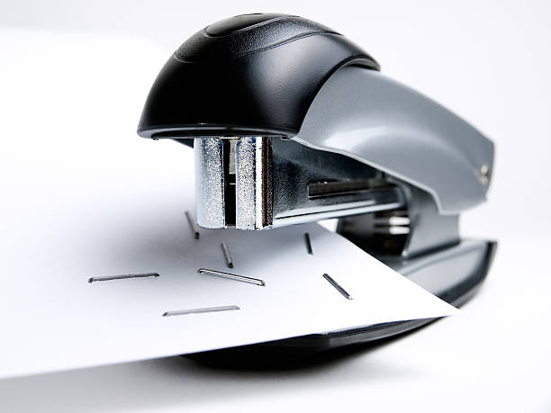 forklift Closeup view of stapler with staples on the paper. stapled paper stock pictures, royalty-free photos & images
