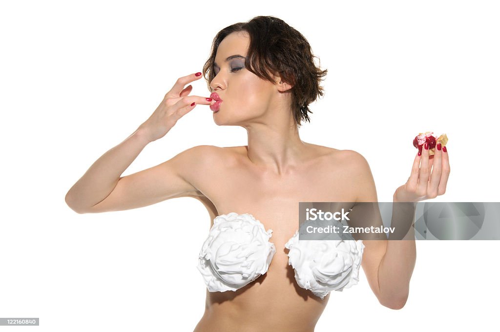 sexy femme avec de la crème sur sa poitrine et licks doigt - Photo de Pâtisserie libre de droits