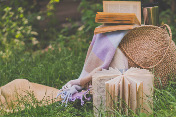 istock Straw bag, book, hat and thermo cup on a sunny summer day 1221608693