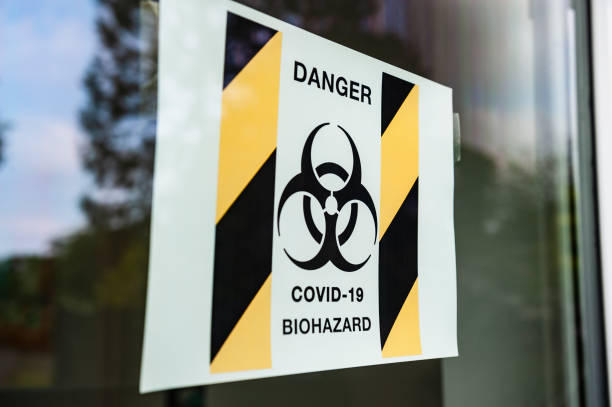 istock DANGER COVID-19 BIOHAZARD sign in window. 1221610622