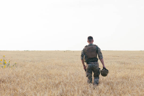 istock Soldier man standing against a field 1221612532