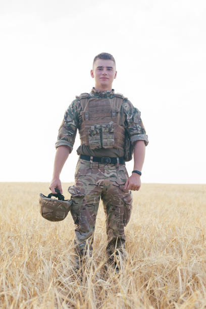 istock Soldier man standing against a field 1221612542
