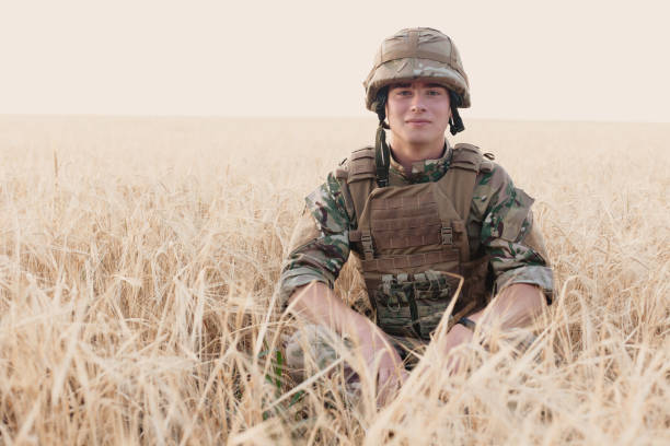 istock Soldier man standing against a field 1221612746