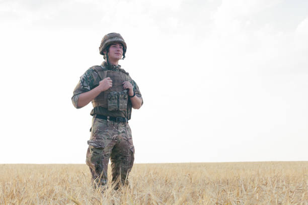 istock Soldier man standing against a field 1221612778