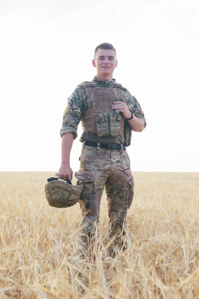 istock Soldier man standing against a field 1221613019