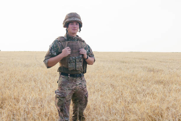 istock Soldier man standing against a field 1221613032