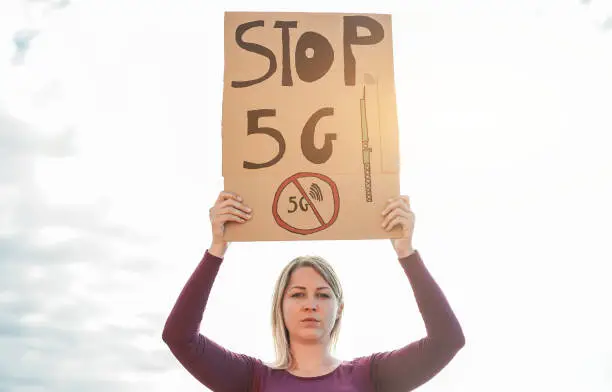 Young woman protest against 5g and cell towers - Electromagnetic pollution and internet of things concept - Focus on banner