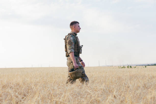 istock Soldier man standing against a field 1221613626