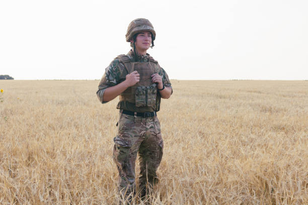 istock Soldier man standing against a field 1221613861