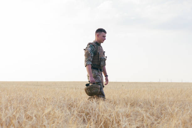 istock Soldier man standing against a field 1221614484