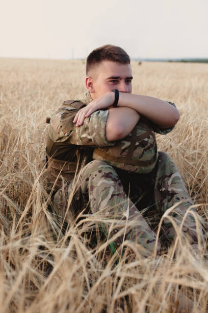 istock Soldier man standing against a field 1221614487