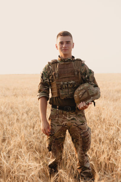 istock Soldier man standing against a field 1221614759