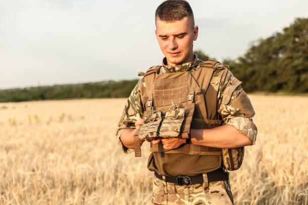 istock Soldier man standing against a field 1221614978