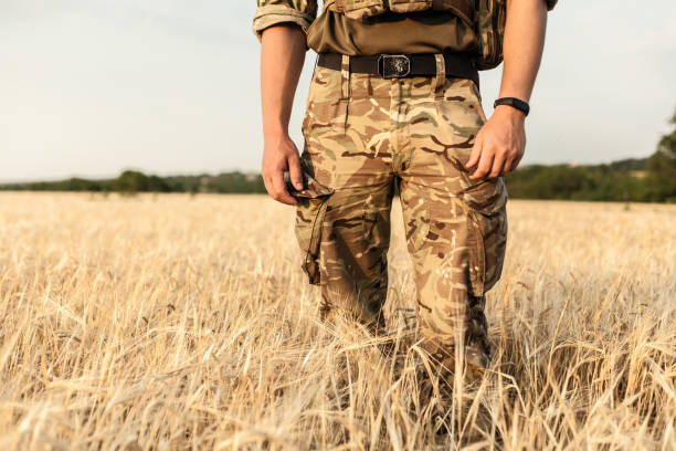 istock Soldier man standing against a field 1221615162