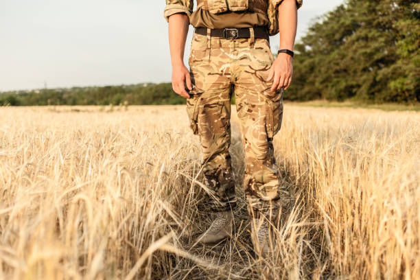 istock Soldier man standing against a field 1221615662