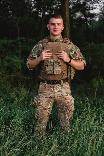 istock Soldier man standing against a field 1221615783