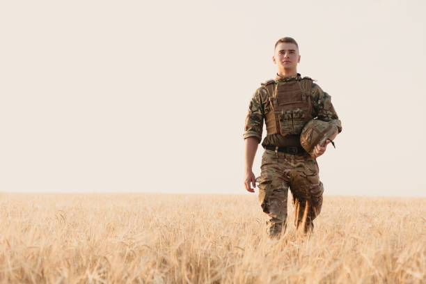 istock Soldier man standing against a field 1221615840