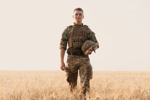 istock Soldier man standing against a field 1221615841