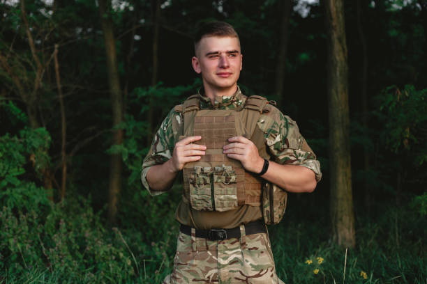 istock Soldier man standing against a field 1221615929