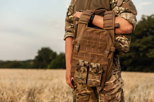 istock Soldier man standing against a field 1221616586