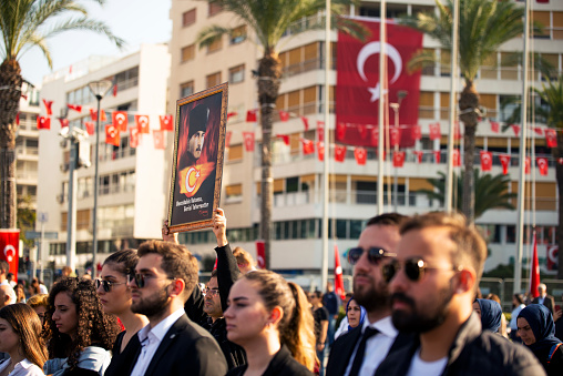 Izmir, Turkey - October 29, 2019. Crowded people with Turkish flags on the background at Republic square in izmir on the day of Republic Turkey. Man holding an Ataturk photo on his hand and it writes âif the subject is the homeland, other issues are detailsâ.