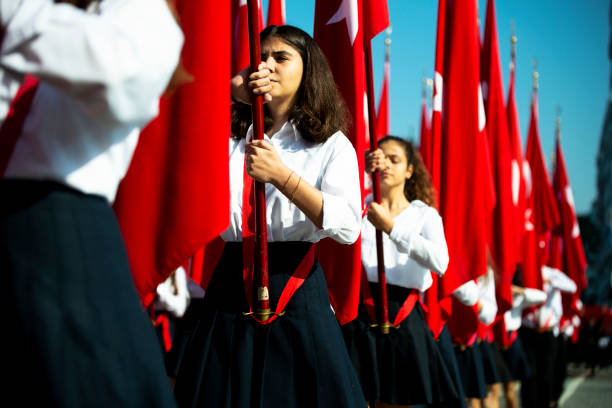 Turkish flags and young female students Izmir, Turkey - October 29, 2019. Red Turkish flags and young female students holding them at ceremony Cumhuriyet Square Alsancak , Izmir. In Republic Day of Turkey Country. april stock pictures, royalty-free photos & images