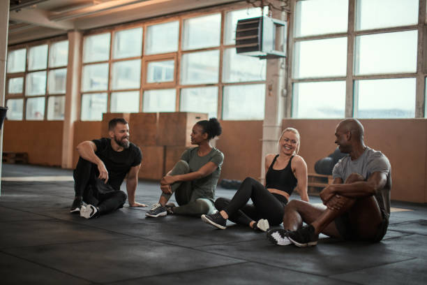 istock Smiling group of diverse friends talking on a gym floor 1221625865