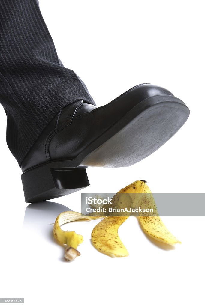 Falling on a banana skin Businessman foot about to slip and fall on a banana skin Banana Peel Stock Photo