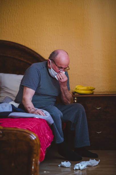 istock Sick man is sneezes in quarantine at home 1221627252