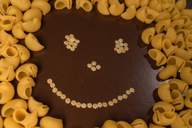istock italian pasta pepe rigate, snails, mugs with a smile on a brown background 1221628291