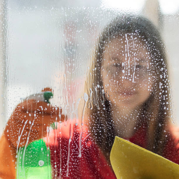 istock A girl is washing windows at home. 1221628363