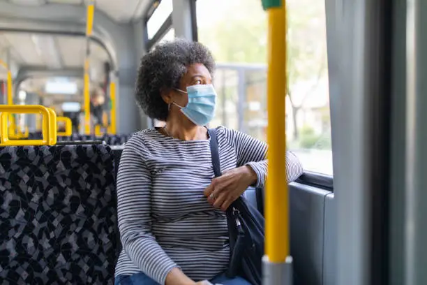 Photo of Woman with face mask travelling in the tram during Covid-19 outbreak