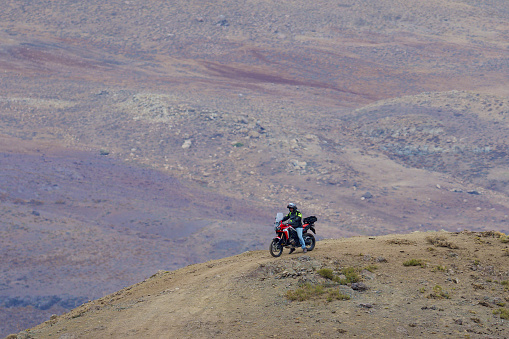 A lone motorcyclist explores off-road tracks in the Andes mountains