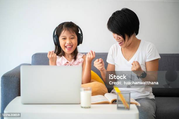 Asian Girl And Her Teacher Using Laptop For Online Study During Homeschooling At Home Stock Photo - Download Image Now