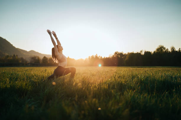 istock Young woman stretching outdoors on a field at sunset 1221630979