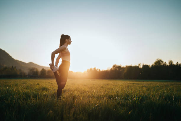 istock Young woman stretching outdoors on a field at sunset 1221631273