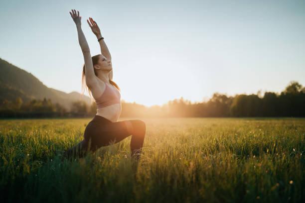 istock Young woman stretching outdoors on a field at sunset 1221631404