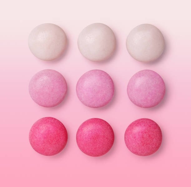istock Group gradient pink drops candies isolated on pink background 1221631458
