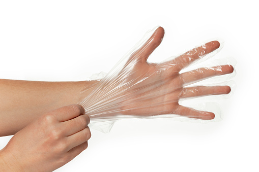 Transparent disposable plastic gloves for shopping at store or cooking on hand, isolated on white background.