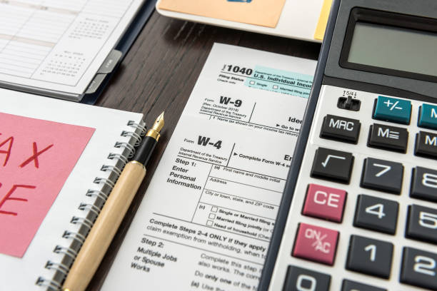 istock Tax form, pen and calculator at office desk 1221633096