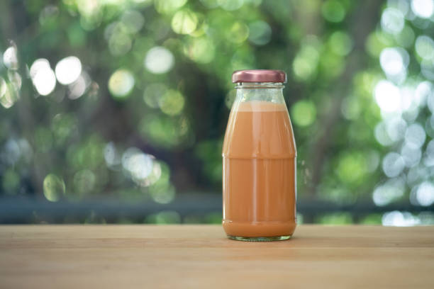 Cold Thai milk tea in a glass bottle put on wood table