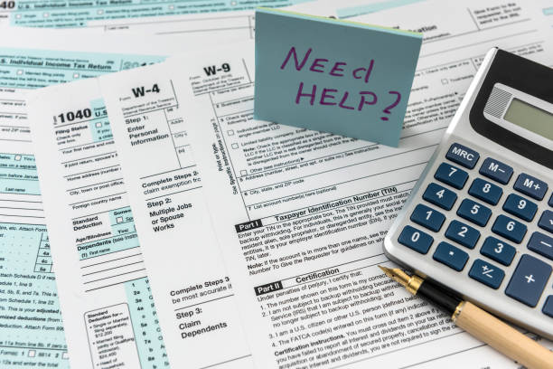 istock Sticker with text Need Help and 1040 tax form, pen and calculator. Deadline 1221634192