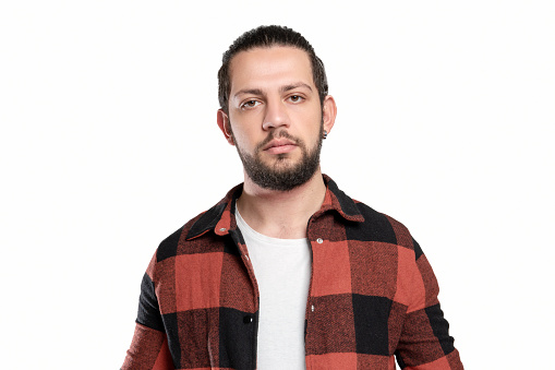 Portrait of serious young man with blank facial expression over white background. Horizontal composition. Studio shot.