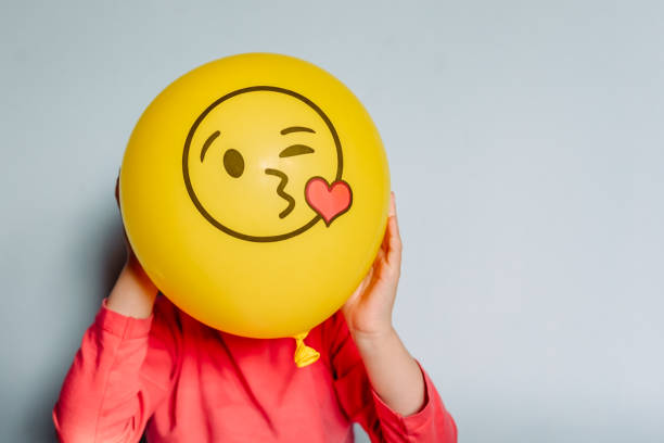 Child holding yellow balloon in the hands