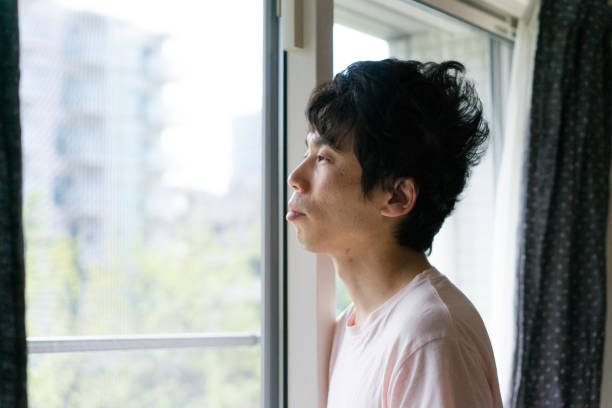 азиатский человек стоял у окна и глядя в окно утром - screen door door porch house стоковые фото и изображения