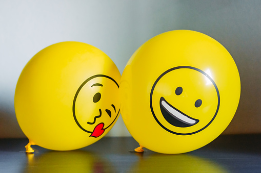 Two yellow balloons against blue background